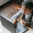 focused young asian girl studying on wireless laptop