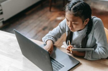 focused young asian girl studying on wireless laptop