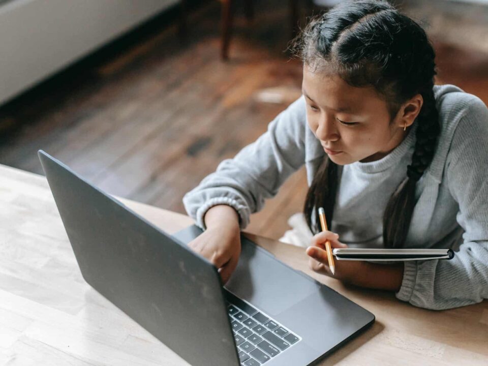 focused young asian girl studying on wireless laptop