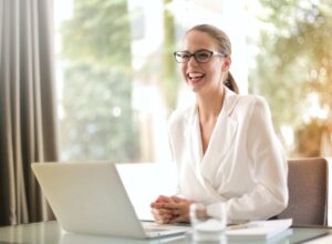 laughing businesswoman working in office with laptop
