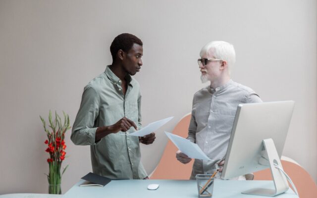 multiracial coworkers with papers in office
