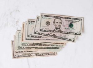 stack of different dollar banknotes on marble table