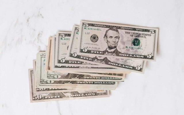 stack of different dollar banknotes on marble table