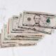stack of different dollar banknotes on marble table