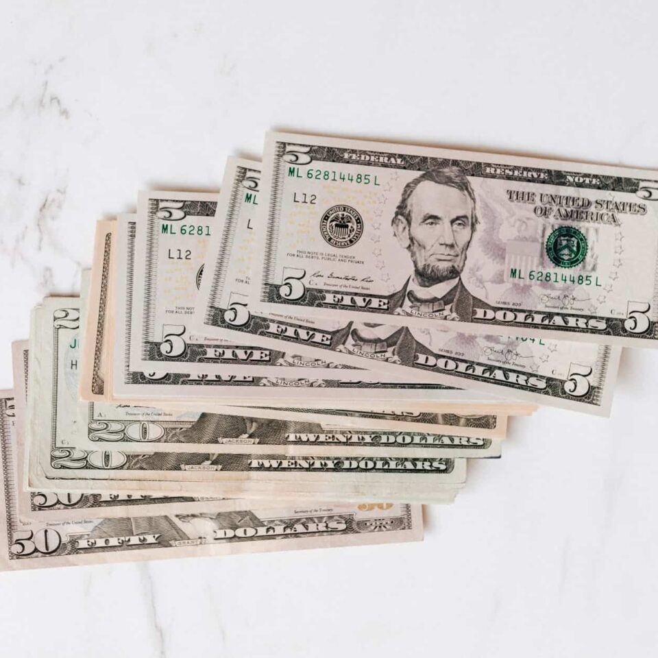 stack of different dollar banknotes on marble table