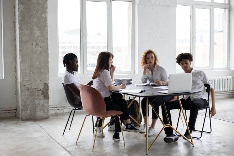 focused diverse colleagues analyzing project together in office