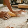 woman making pastry on table with flour