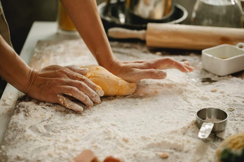 woman making pastry on table with flour